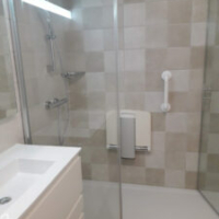 salle de bain pour personnes âgées équipés d'un siège de douche et de barre de maintien